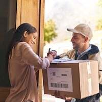 Shot of a young woman signing for her delivery from the courier